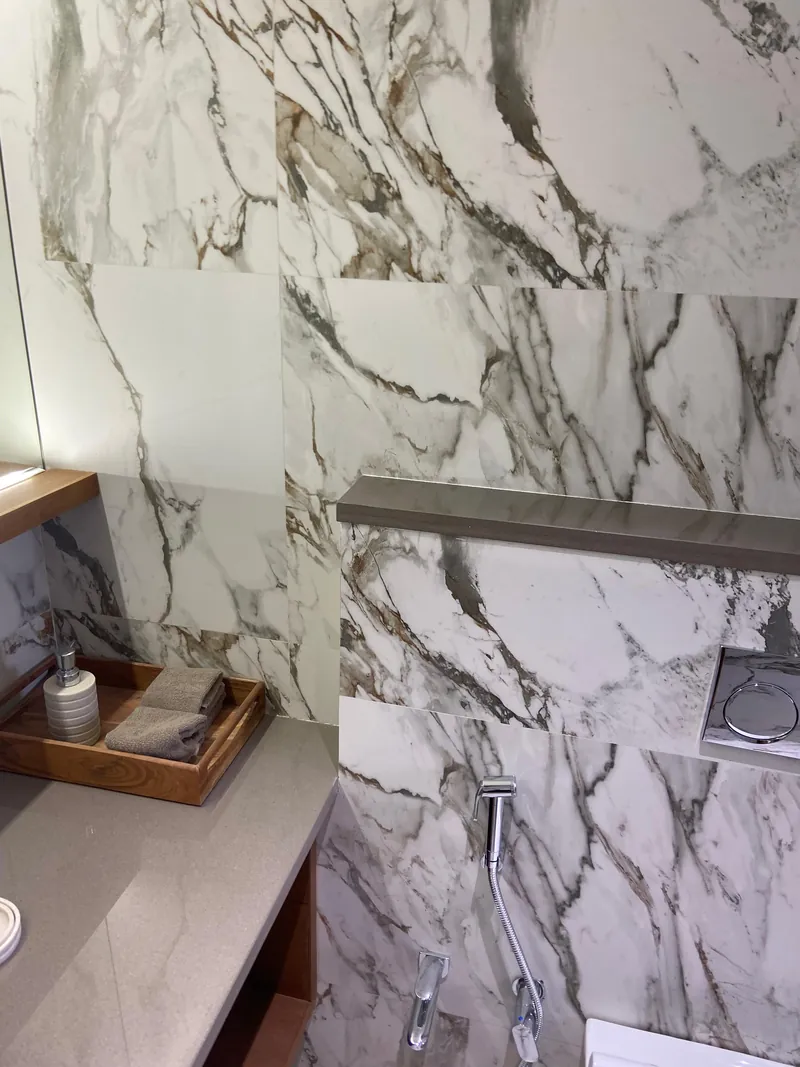 Luxury bathroom with book-matched marble walls and stone countertop vanity.