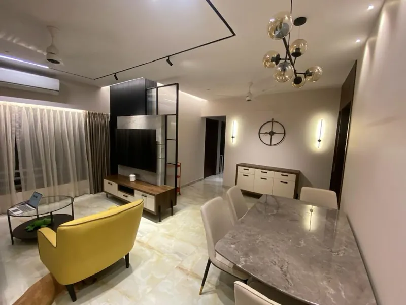 Open living-dining area with TV unit, sputnik chandelier and marble table.