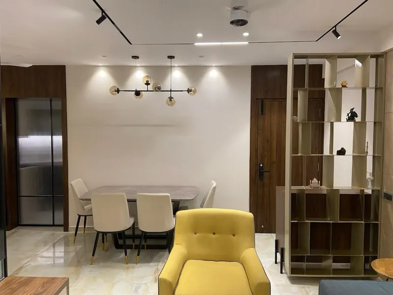 Contemporary dining area with stone table, display shelving and pendant light.