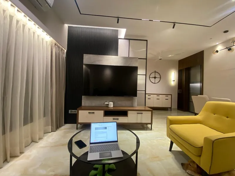 Modern living room with slatted TV feature wall and yellow sofa.