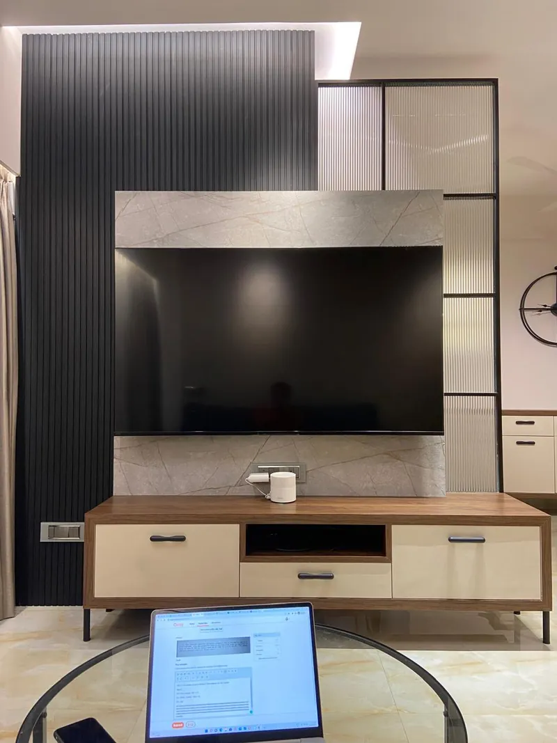 Portrait view of slatted TV wall with marble panel and media console.