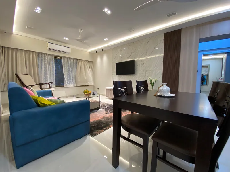 Open living-dining space with marble TV feature wall and dark wood dining set.